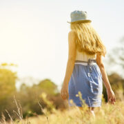 Shot of a young woman on a tree stump out in the countryside.