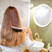 woman combing her hair in bathroom